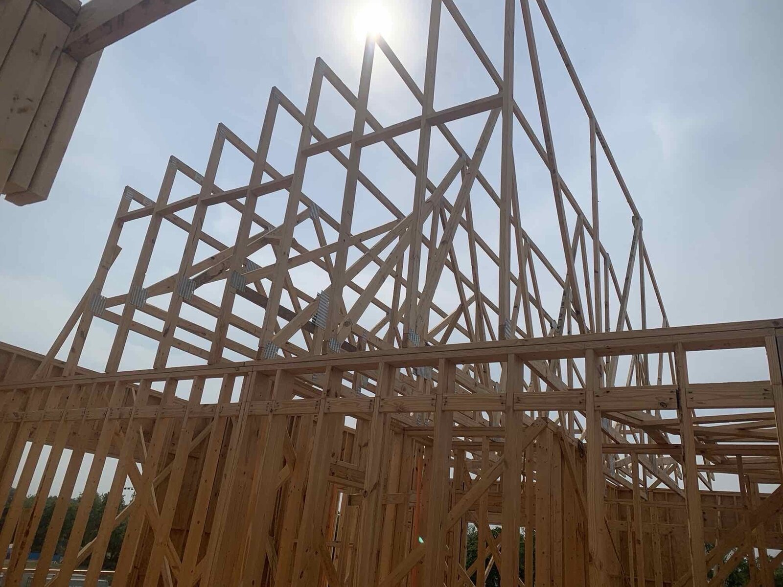 Close-up of roof truss peak framing against a clear sky