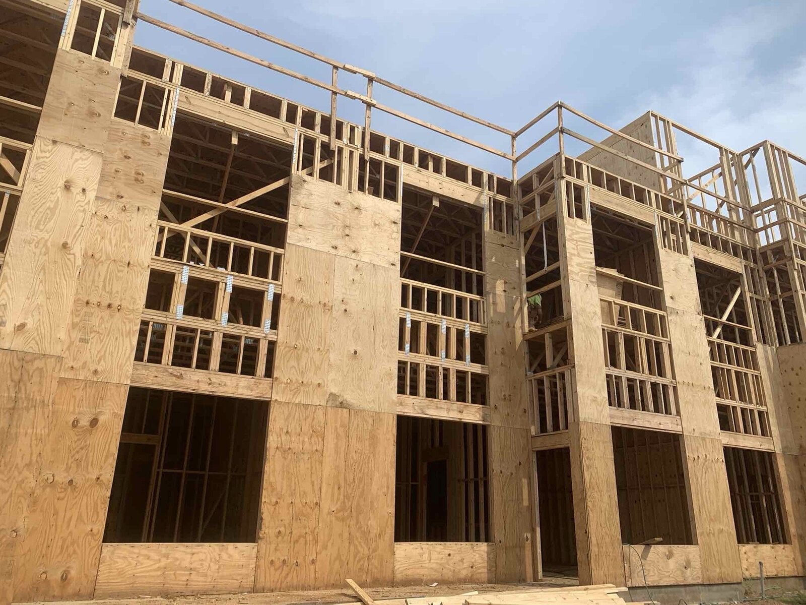 Multi-story wood-framed building corner under construction