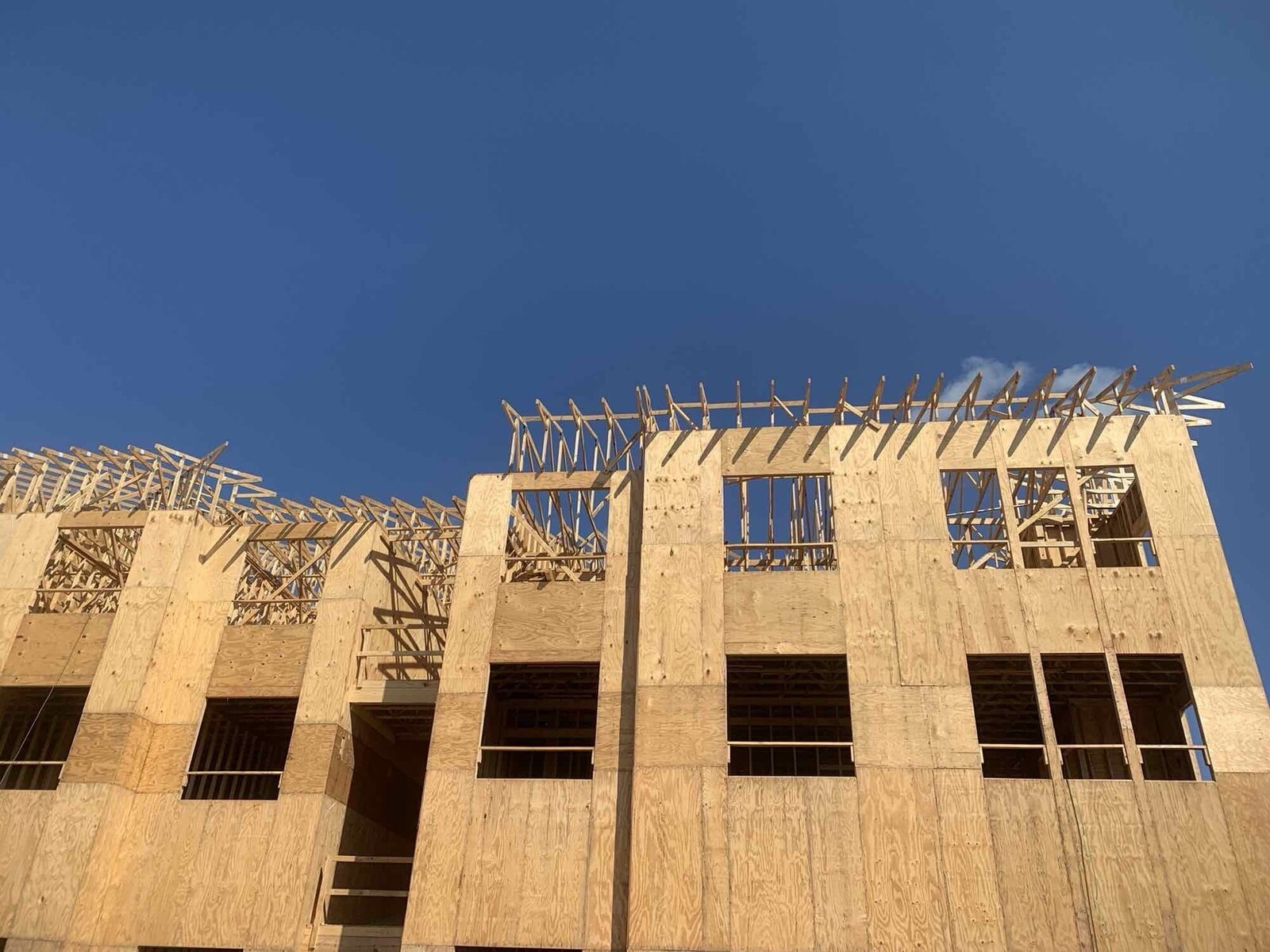 Multi-family building framing against a deep blue sky