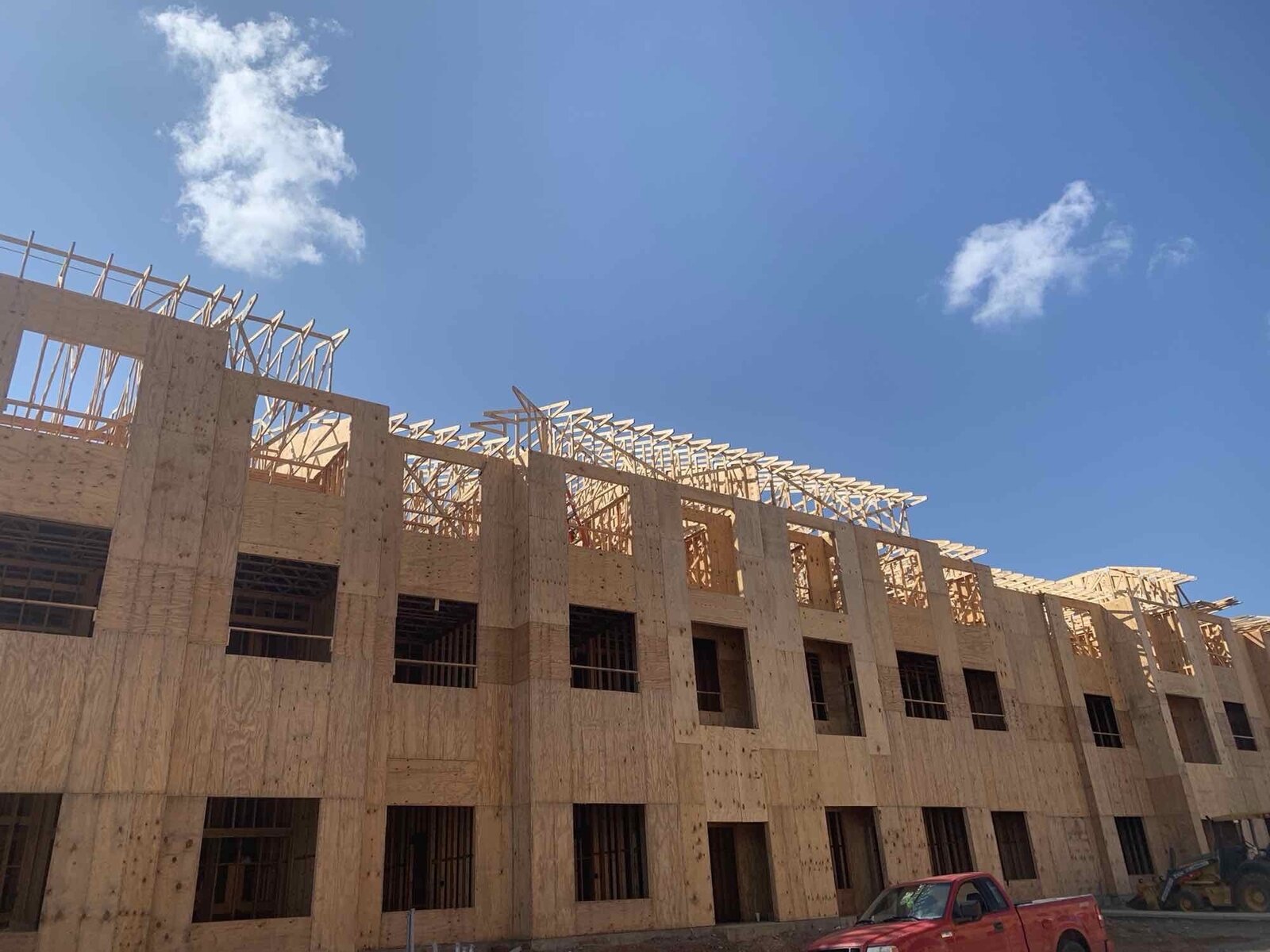 Framed multi-family building with work truck staged on site