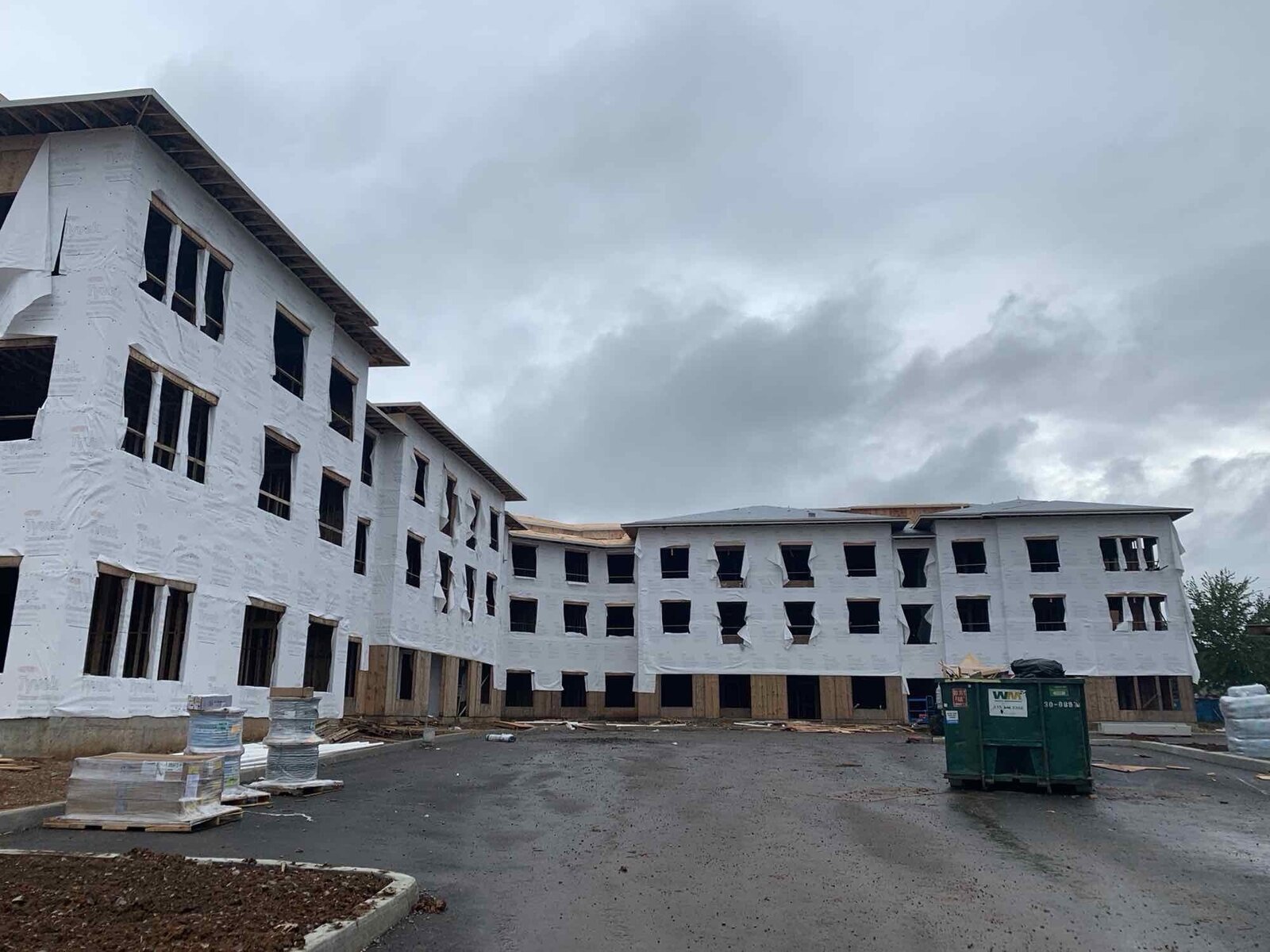 Multi-family building with house wrap installed, progressing toward exterior finishes