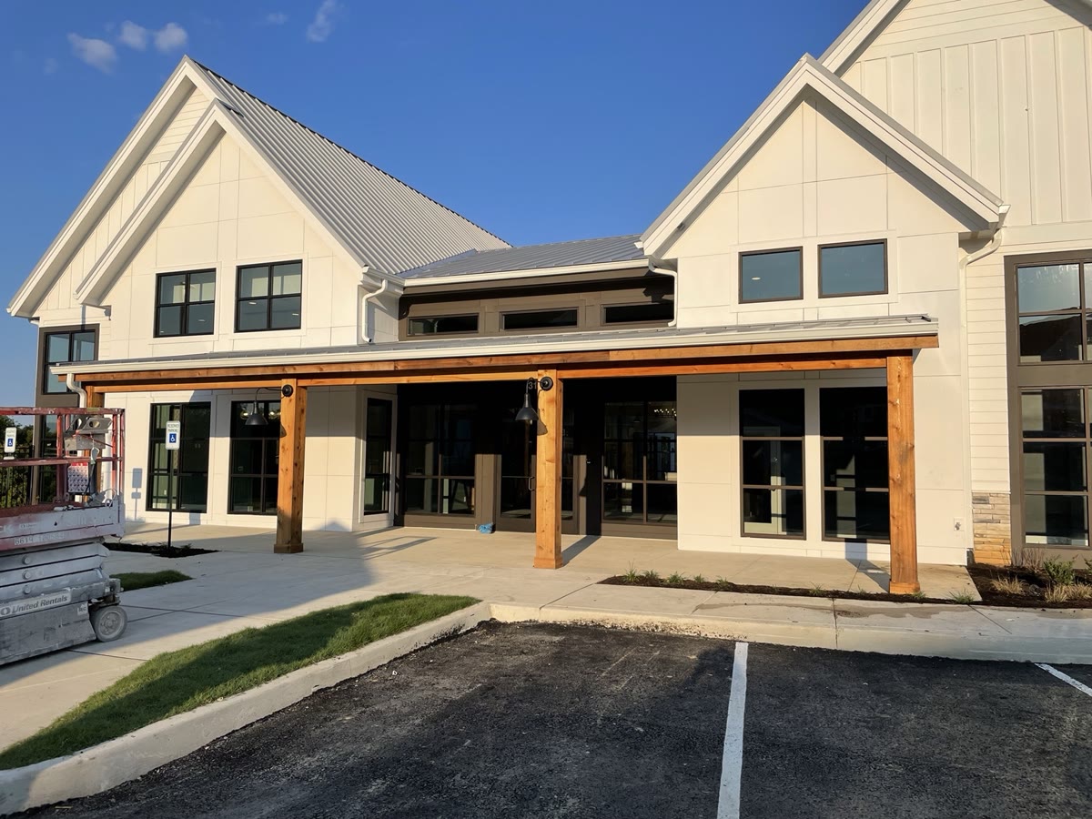 Completed multi-family building facade with stone accent and craftsman entry