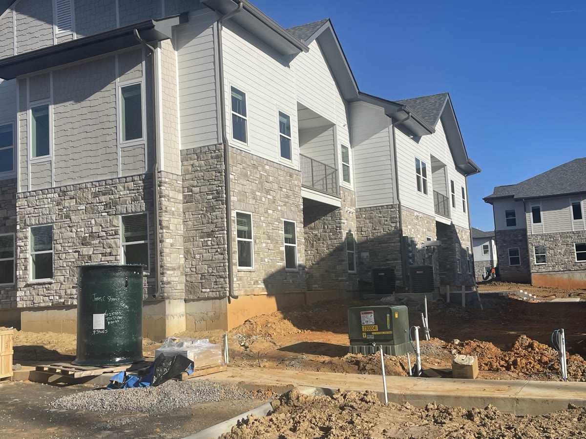 Completed multi-family townhome row with stone and siding exterior
